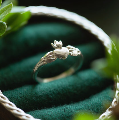 Vista laterale dell'anello Claddagh in argento 925, con dettagli botanici che abbracciano il cuore.