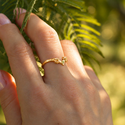 Anello Driade in oro giallo 18 kt con peridoto verde indossato sulla mano, con dettagli di foglie d'edera.
