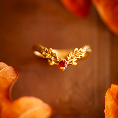 Anello Foglia d'Autunno in oro giallo 18 kt con granato rosso e dettagli a foglia di quercia, realizzato a mano da Blossom Gioielli.