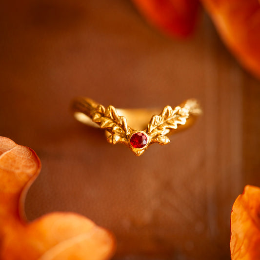 Anello Foglia d'Autunno in oro giallo 18 kt con granato rosso e dettagli a foglia di quercia, realizzato a mano da Blossom Gioielli.