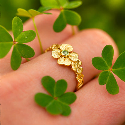 Anello Quadrifoglio in oro giallo 18 kt indossato sulla mano, con dettagli di trifogli e un quadrifoglio centrale portafortuna.