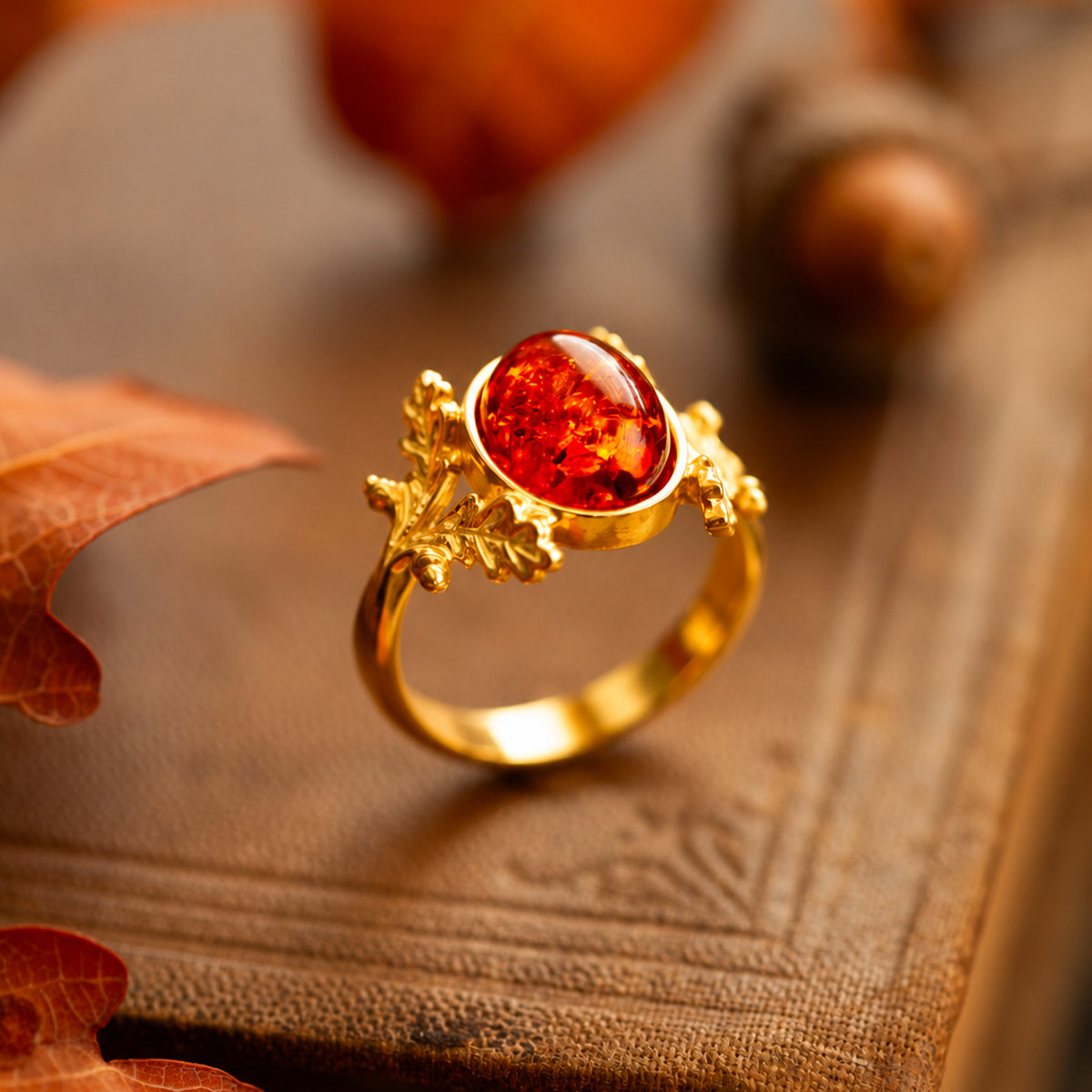 Anello Quercia in oro giallo 18 kt con ambra baltica, decorato con piccole foglie di quercia e ghiande, realizzato a mano da Blossom Gioielli.